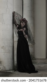 Gothic Woman In Mysterious Place, Long Black Victorian Dress Create Dramatic Atmosphere. Classic Horror Scene.