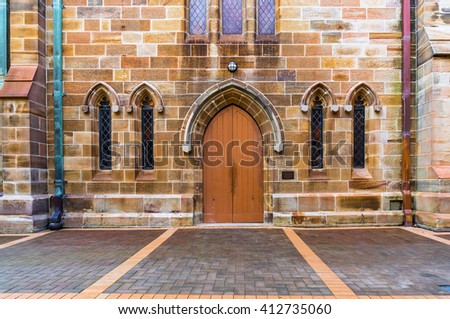 Gothic wooden old church door and narrow windows with color glass