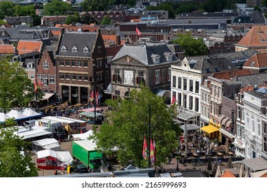 Gouda, The Netherlands-June 2022; High angle view of the historic Waag (weigh house) and other historic buildings on the market square during a busy market day with market stalls on the square