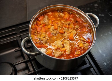 Goulash In A Stainless Steel Pot On A Black Stove, Top View