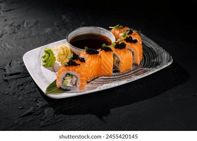 Gourmet arrangement of salmon sushi rolls topped with caviar served with soy sauce - Powered by Shutterstock