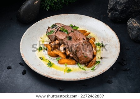 Gourmet beef medallions dish with potatoes and mushrooms. Fresh beef medallions with mushroom sauce and sliced fried potato.