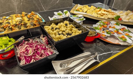 A gourmet buffet spread featuring assorted cheeses, marinated vegetables, and smoked fish, ideal for catering events or festive gatherings