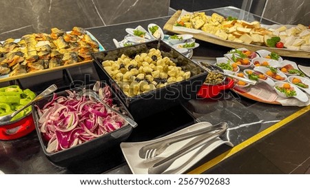 A gourmet buffet spread featuring assorted cheeses, marinated vegetables, and smoked fish, ideal for catering events or festive gatherings
