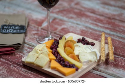 Gourmet Cheese Platter On Red Barnwood Background