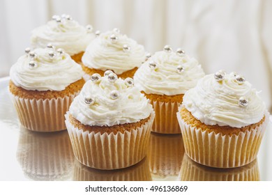 Gourmet cupcakes with white buttercream frosting and sprinkles