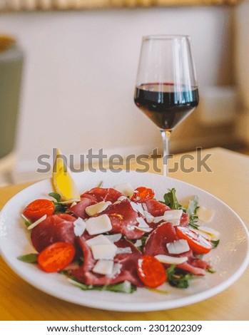 A gourmet dish of beef carpaccio and Parmesan cheese
