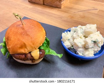 Gourmet hamburger with boerewors sausage, cheese and fresh lettuce. A potato salad side with a burger - Powered by Shutterstock