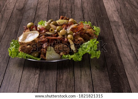 Gourmet horizontal photograph of Portion of fried chicken made with rustic onions, bacon, olives and lettuce. Fried Chicken. Brazilian typical food. Bottom space for text.