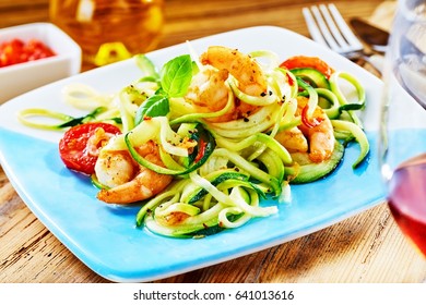 Gourmet low carbohydrate seafood appetizer with spicy grilled prawn tails in a fresh raw vegetable salad served with wine