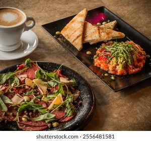 A gourmet meal featuring salmon tartare with toast, beef carpaccio