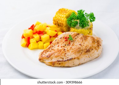 Gourmet Meal: Grilled Chicken Breast With Mango Salsa And Grilled Corn On White Plate, Studio Isolated