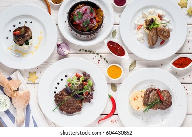 Gourmet meat meals assortment flat lay. Top view on restaurant table with menu of tasty grilled snacks. Buffet, appetizing, delicious food, barbecue concept - Powered by Shutterstock
