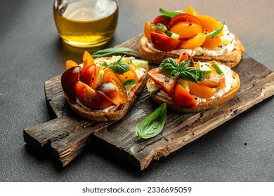 Gourmet sandwiches bread toast, bruschetta with cream cheese, peaches, tomatoes and green basil leaves, - Powered by Shutterstock