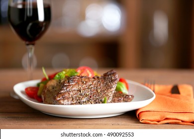 Gourmet steak with vegetables and glass of red wine on wooden table - Powered by Shutterstock