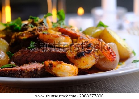 Gourmet surf and turf cajun shrimp and steak dinner entree with new potatoes at a fancy expensive wedding