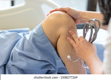 Gout pain syndrome concept. Doctor check up  or exam patient knee bone and joint for patellofemoral infection  and osteochondritis in hospital.