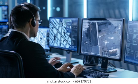 Government Agent Is Tracking Fugitive With Her Computer In Big Monitoring Room Full Of Computers With Animated Screens.