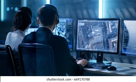 Government Agent Is Tracking Fugitive With Her Computer In Big Monitoring Room Full Of Computers With Animated Screens.