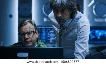 Government Chief of Cyber Security Consults Military Officer who Works on Computer. Specialists Working on Computers in System Control Room.