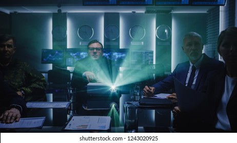 Government Officials, Military Men And Business Executives Watching Presentation In The Conference Room. Working Projector On The Table. Collaboration Of Important People.