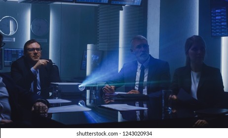 Government Officials, Military Men And Top Corporate Executives Watching Presentation In The Conference Room. Working Projector On The Table.