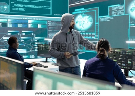Governmental hackers analyzing data for cyber threat detection, looking at a big screen in high tech office. Highlight cyber intelligence, online security and prevention of digital threats.