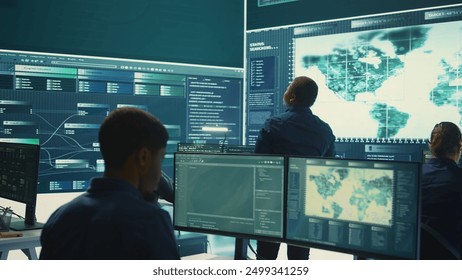 Governmental hackers exploiting network systems in high tech office, executing cyber operations for national server security. Focus on data protection and online safety to combat cybercrime. Camera B.