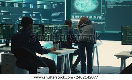 Governmental hackers team securing computer systems from cyber threats, working together in agency control room. Emphasizing encryption, online security and espionage against cyber attacks. Camera A.