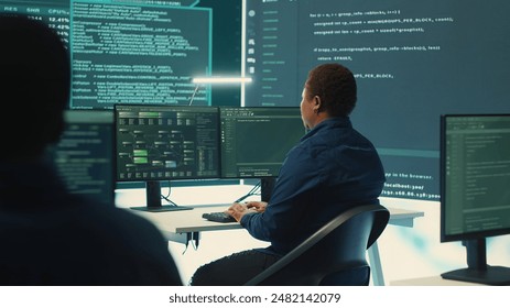 Governmental hackers using advanced software to protect against cyber threats, working in team. Specialists on cyber security, data and network protection unite forces in high tech office. Camera A.