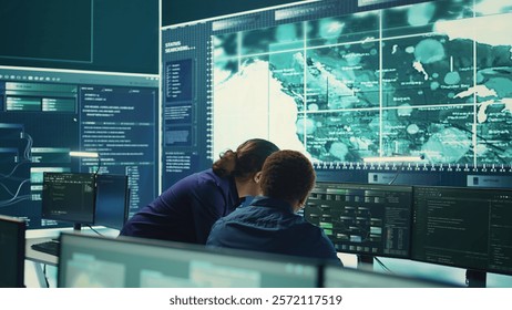 Governmental hackers using advanced software to protect against cyber threats, working in team. Specialists on cyber security, data and network protection unite forces in high tech office. Camera B.