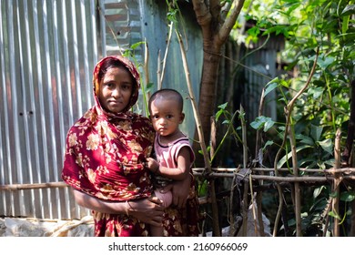 Gowainghat, Bangladesh – November 06, 2019: A woman becomes an early mother because of early marriage in Bangladesh and child on her lap overcoming the curse of malnutrition in a rural village.