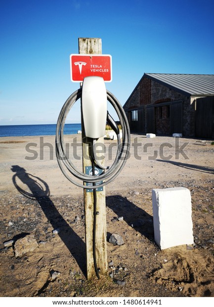 Gower, UK: August 15, 2019: Tesla Electric Vehicle\
charging station on a remote beach in Gower - UK. The Model S Long\
Range has an EPA range of 370 miles (600 km), higher than any other\
electric car.