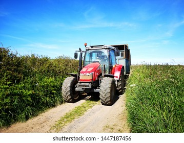 Gower, UK: June 23, 2019: A Farm Worker Is Driving A Tractor In The Lanes Around The Fields. 