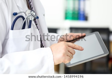 GP using mobile electronic communication device for patient diagnosing and examination in hospital close-up