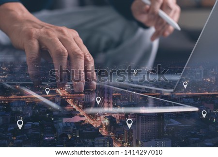 GPS map, pin address location on mobile apps. Double exposure of man hand using digital tablet searching target place on night cityscape while working on laptop computer.