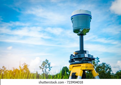 GPS Surveying Equipment On Blue Sky And White Clouds Background. GPS, GIS, And GNSS Equipment. Land Survey For Map. Technology For Marks Land To Made Satellite Map On The Earth. Smart GNSS,GPS Survey.