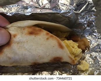 Grab A Austin , Texas Tex-mex Flour Tortilla BreakFast Taco With Scrambled Eggs And Bacon And Potatoes  On Foil 