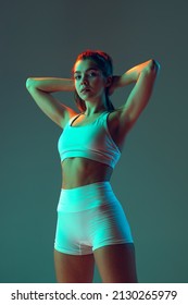 Grace  Portrait sportive woman workout  doing exercises and sports equipment isolated green studio background in neon light  Sport  gym  action  motion  beauty concept  Fitness  hobby  health