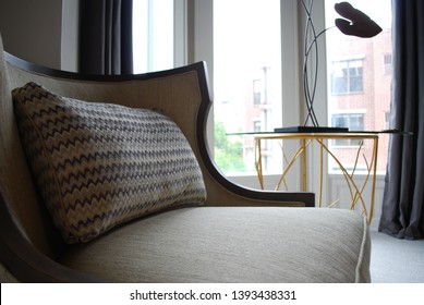 Graceful Cream Fabric Chair With Dark Wooden Frame And Zigzag Patterned Lumbar Pillow. 