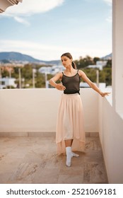 A Graceful Dancer is Posing Elegantly on a Beautiful Balcony with a Scenic Background View