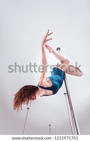 Graceful movements. Young skillful pole dancer feeling good while showing amazing graceful movements