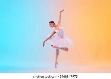 Graceful and poised young ballet dancer performs dance moves in action in neon light against blue-orange gradient background. Concept of art, movement, classical and modern fusion, beauty and fashion
