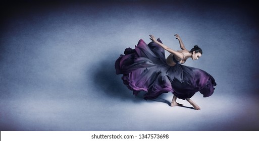 Graceful Woman Dancing In Flowing Dark Blue Dress Like Flower