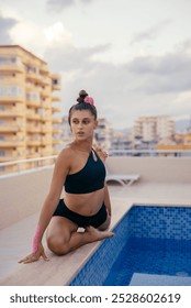A Graceful and Young Dancer is Posing Elegantly by a Beautiful Rooftop Pool Area