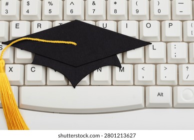 Grad cap on white computer keyboard for e-learning and remote learning