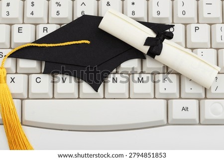 Grad cap on white computer keyboard for e-learning and remote learning