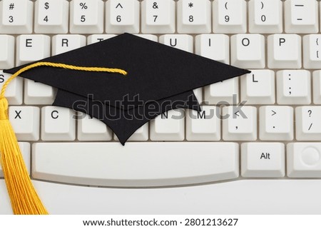 Grad cap on white computer keyboard for e-learning and remote learning