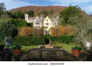Grade I listed Tudor Owlpen Manor with 19th century Church of the Holy Cross behind. Uley, Gloucestershire, UK
