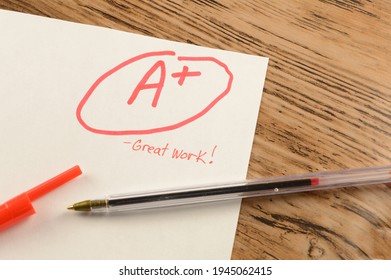 A graded school paper marked in red ink over a wood desktop. - Shutterstock ID 1945062415